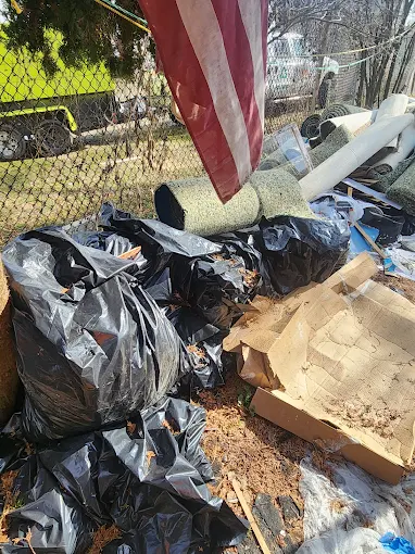 Trash bags and debris piled on a lawn ready for junk removal pickup