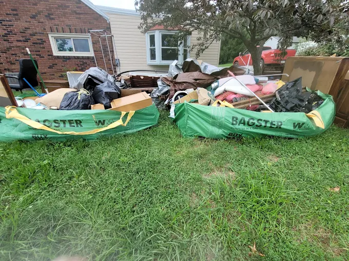 Two contractor bags full of debris on a lawn, ready for pickup