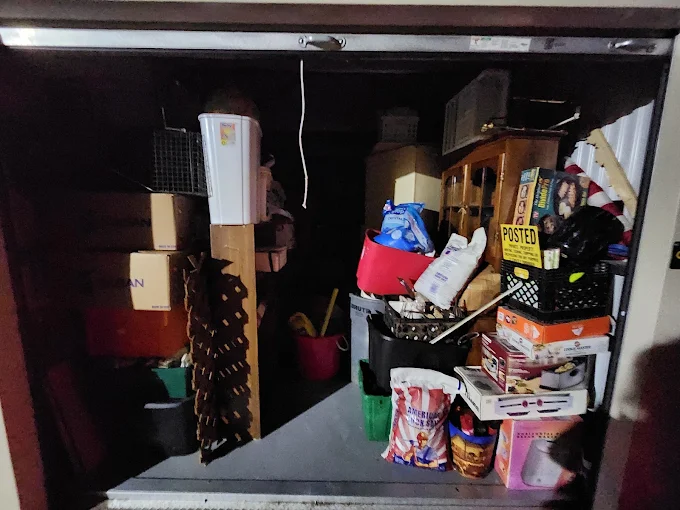 Storage unit packed with boxes and miscellaneous items before cleanout